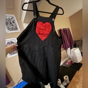 Black corduroy overall jumper dress with red sequin heart detail.